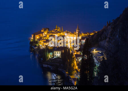 Il lago di Como, Provenza di Lecco, le luci di Varenna village di notte. Lombardia, Italia Foto Stock