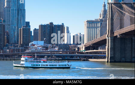 Una linea Circle tour in barca sul fiume est nella città di New York passando il Ponte di Brooklyn Foto Stock