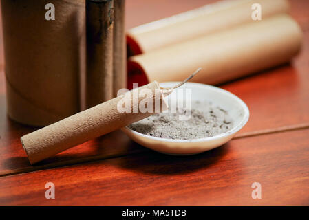 Close up di marrone petardi vicino ad un vaso bianco con la polvere da sparo,  su di un tavolo di legno Foto stock - Alamy