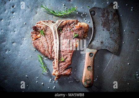 Deliziosi e freschi tbone bistecca con erbe aromatiche e sale Foto Stock