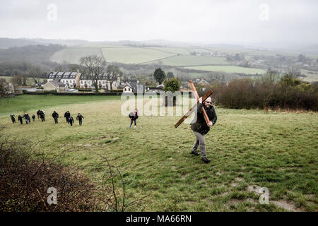 Una croce di legno è portato fino Roundhill in bagno, Wiltshire, dove molti cristiani della Chiesa le congregazioni prendere parte nel cammino di testimonianza di imitare il cammino che Gesù ha preso portando la sua croce attraverso le strade di Gerusalemme nel giorno di Venerdì Santo. Foto Stock