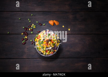 Insalata fresca con mais e miscelati su sfondo di legno vista dall'alto. Cibo sano. Foto Stock