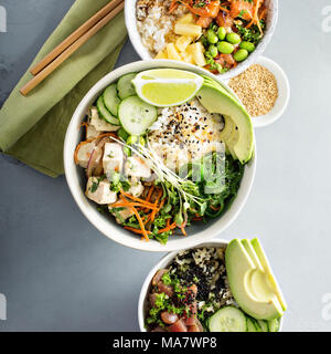 Varietà di poke ciotole con tonno, salmone e tofu su riso con verdure Foto Stock