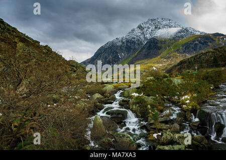 Snow capped monte Tryfan, Afon ogwen cascading la sua strada giù per la montagna. Foto Stock