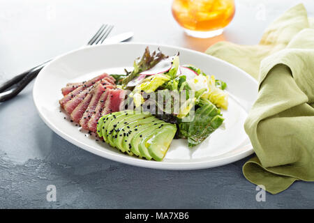 Bistecca di tonno con insalata di avocado a fette e lattuga Foto Stock