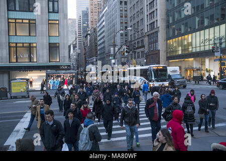 Pedoni in crosswalk al sempre occupato angolo della Quinta Avenue e la 42th Street nel centro di Manhattan, New York. Foto Stock