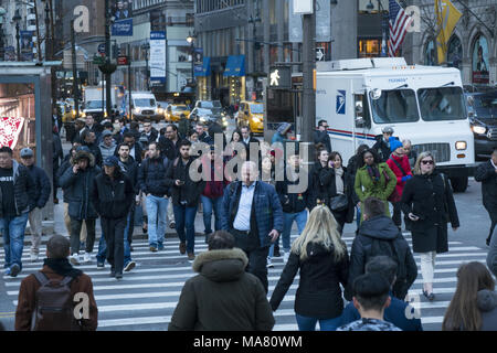 Pedoni in crosswalk al sempre occupato angolo della Quinta Avenue e la 42th Street nel centro di Manhattan, New York. Foto Stock