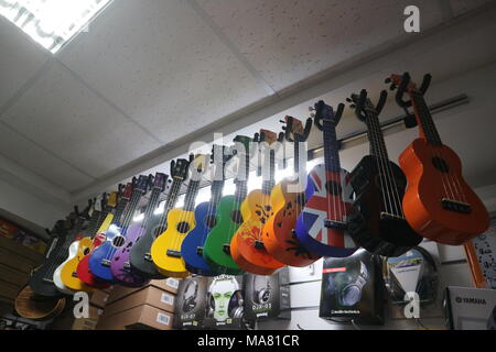 Multi-colore di ukulele chitarre in uno strumento musicale store Foto Stock