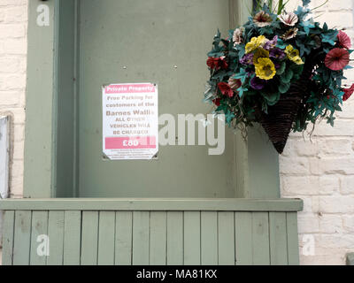 Avviso di parcheggio e cestino di fiori falsi sulla chiusa Barnes Wallis Public House, Howden, vicino a Goole, East Yorkshire, Inghilterra Foto Stock