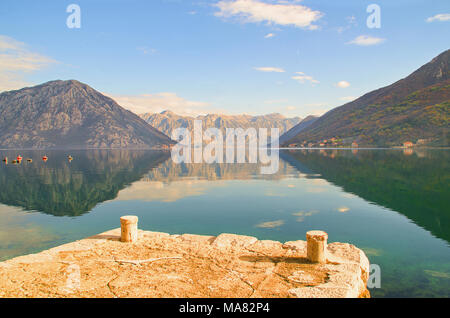 La Baia di Kotor con drammatiche riflessioni di montagna e Perast e monte Lovcen in background Foto Stock
