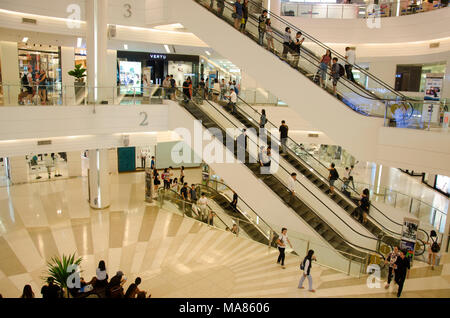 Persone sedute e attendere al punto di incontro e di gente che passeggia e usare escalator per muovere in su e in giù per lo shopping al department store in maggio 23, 2017 Foto Stock