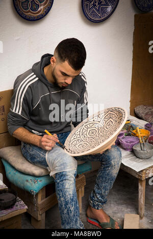 Il Marocco, Fes, Quartier des Potiers, ceramiche, lavoratore di decorazione a mano geometrico piatto modellato Foto Stock