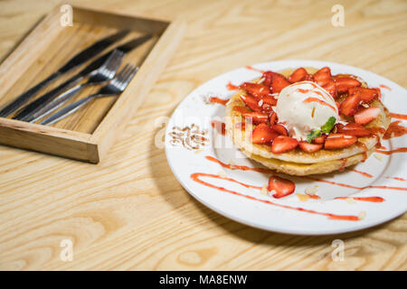 Toast con gelato e fragole fresche con panna montata sulla piastra bianca Foto Stock