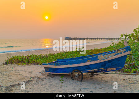 Tramonto al di ancoraggio barca da pesca con la bassa marea. Foto Stock