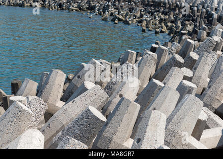 Tetrapods concreti sul fronte mare per prevenire erosione costiera Foto Stock