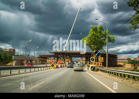 Mosca, Russia - 5 giugno 2015. in costruzione e cavalcavia attraverso l'autostrada Leningrado contro un cielo tempestoso Foto Stock