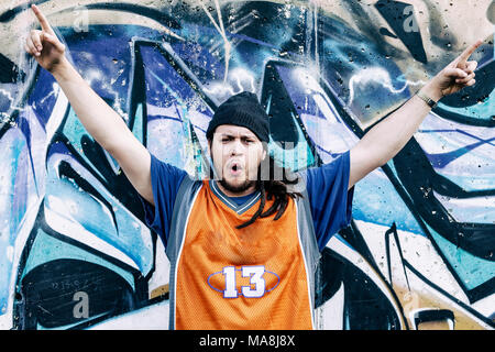 Tre cantanti rap in una metropolitana con graffiti in background Foto Stock