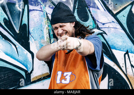 Tre cantanti rap in una metropolitana con graffiti in background Foto Stock