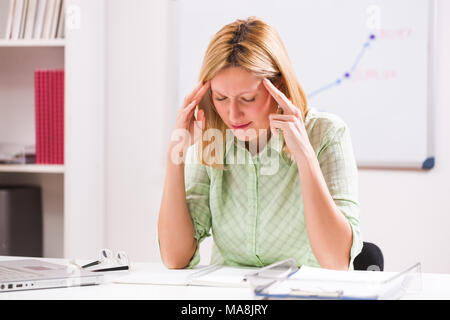 Imprenditrice di avere mal di testa al lavoro. Foto Stock