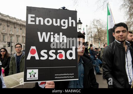 Un giovane manifestante siriano è in possesso di un cartellone di lettura: "Basta con Assad" al di fuori di Downing Street a Londra, Regno Unito. Foto Stock