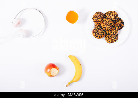 Top View colazione o uno spuntino. Snack sani: cookie, tazza di succo di frutta, mela e banana su sfondo bianco. Piano di composizione dei laici. Foto Stock