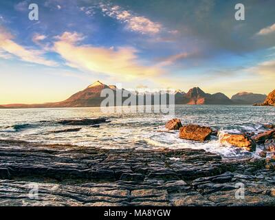 La famosa Baia rocciosa di Elgol sull'Isola di Skye in Scozia. Il Cuillins mountain in background. Fotografato al tramonto. Foto Stock