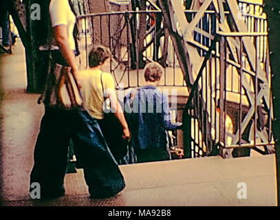 Parigi, Francia - circa 1976: Turisti in 70s abito, scendendo dal ponte di osservazione di Parigi dalla Torre Eiffel. Archivio Storico di riprese in Parigi città della Francia negli anni settanta. Foto Stock