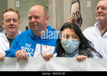Manifestanti con David Cameron maschera alla Vergine Care HQ a Londra chiamata per porre fine alla società privata utilizzando il logo di NHS e per la Vergine a smettere di elusione fiscale. Foto Stock