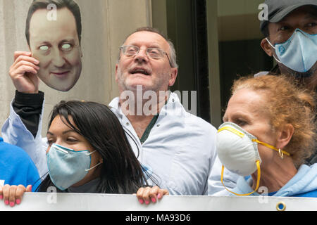 Manifestanti con David Cameron maschera alla Vergine Care HQ a Londra chiamata per porre fine alla società privata utilizzando il logo di NHS e per la Vergine a smettere di elusione fiscale. Foto Stock