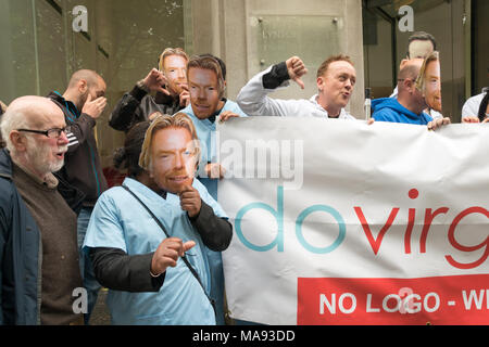 Manifestanti con Richard Branson maschere a cura di vergine HQ a Londra chiamata per porre fine alla società privata utilizzando il logo di NHS e per la Vergine a smettere di elusione fiscale. Foto Stock