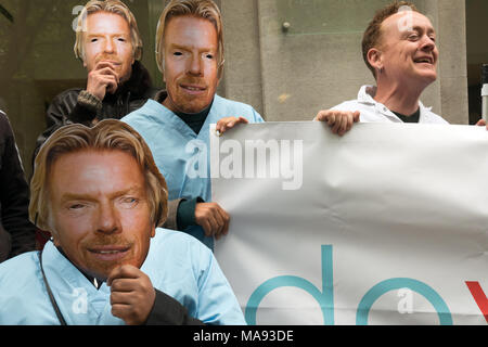 Manifestanti con Richard Branson maschere a cura di vergine HQ a Londra chiamata per porre fine alla società privata utilizzando il logo di NHS e per la Vergine a smettere di elusione fiscale. Foto Stock