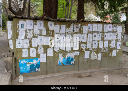 Avvisi commemorativi e/o avvisi di morte (poster o necrolos) su una bacheca nel villaggio di Rila, Bulgaria sud-occidentale. Foto Stock