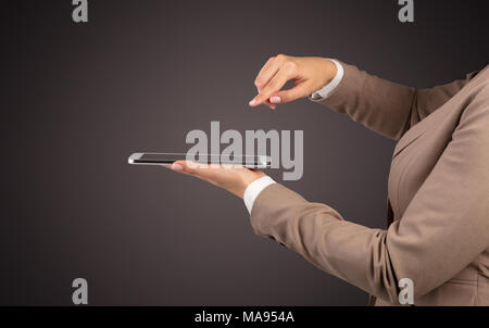 Mano femminile in tuta azienda tablet con nessun wallpaper Foto Stock