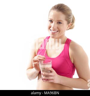 Giovane donna in abbigliamento sportivo di bere protein shake, studio shot. Foto Stock