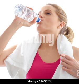 Giovane donna di bere da una bottiglia d'acqua, studio shot. Foto Stock