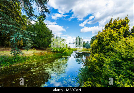 Frogmore House, Frogmore station wagon, Windsor, Berkshire, Regno Unito con riflessi del cielo blu e bianchi e soffici nuvole nel lago in estate Foto Stock