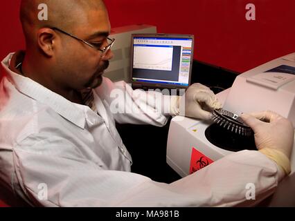 Fotografia del CDC biologo Damian Danavall e un NCHHSTP membro dello staff, lavora in un laboratorio accanto ad una macchina e ad un computer utilizzando un cycler PCR per replicare DNA o RNA sequenze molecolari, in uno sforzo per analizzare le malattie sessualmente trasmissibili, 2007. Immagine cortesia CDC/Hsi Liu, James Gathany. () Foto Stock