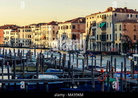 I pali di ormeggio (briccola) sul Canale Grande o il Grand Canal, piccolo molo con barche ormeggiate e gli edifici residenziali in background Foto Stock