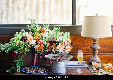 Lussuosa e squisita ora di cocktail, bachelorette, tavolo di compleanno che definisce la natura morta floreale con champagne e cioccolato Foto Stock