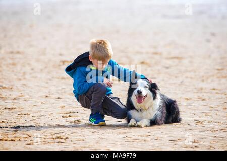 Lytham St Annes, nel Lancashire. Il 30 marzo 2018. Regno Unito Meteo. Un giovane ragazzo porta il suo migliore amico fuori per un po' di divertimento sulla spiaggia nella pittoresca località balneare di Lytham St Annes in Lancashire. Credito: Cernan Elias/Alamy Live News Foto Stock