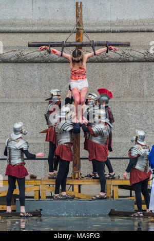 Londra, Regno Unito. Il 30 marzo, 2018.Gesù viene portato giù dalla croce - Wintershall giocatori open-air rievocazione della 'La Passione di Gesù " il Venerdì Santo sotto la pioggia in Trafalgar Square. È caratterizzato da un cast di oltre cento volontari di in ed intorno a Londra. Credito: Guy Bell/Alamy Live News Foto Stock
