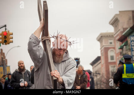 New York, Stati Uniti d'America. Il 30 marzo, 2018. I parrocchiani della parrocchia e del clero di membri da Frati Francescani del Rinnovamento di raccogliere in Harlem a New York per la loro annuale via della croce la testimonianza a piedi il Venerdì Santo, 30 marzo 2018. La processione inizia a San Giuseppe convento in Harlem e termina dopo alcune ore presso il San Crispino convento nel Bronx dove un Buon Venerdì servizio avviene. Diverse centinaia di parrocchiani nonché il clero hanno partecipato alla manifestazione, parte della Settimana Santa che commemora la crocifissione di Gesù Cristo. (© Richard B. Levine) Credito: Richard Levine/Alamy Live News Foto Stock