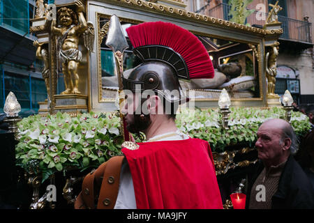 Palermo, Sicilia, Italia. 30 Mar, 2018. Un sarcofago contenente una figura di Gesù passa attraverso le strade di Palermo seguita da credenti cristiani. Il venerdì santo prima di Pasqua numerose processioni riempire le strade di Palermo, la capitale della regione Sicilia in Italia meridionale. Le celebrazioni religiose sono molto importanti momenti profondamente sentito tra le persone. La processione del Venerdì santo hanno normalmente due figure di Gesù e di Maria Santissima. Credito: ZUMA Press, Inc./Alamy Live News Foto Stock