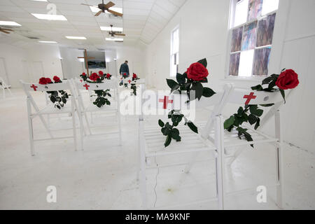 Interno della prima chiesa battista di Sutherland Springs, TX, ora è un memoriale di stark al 26 congregazione membri ucciso durante il servizio nel novembre 2017, con un'unica sedia bianca e rosa rossa per commemorare ciascuna vittima. Foto Stock