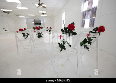 Interno della prima chiesa battista di Sutherland Springs, TX, ora è un memoriale di stark al 26 congregazione membri ucciso durante il servizio nel novembre 2017, con un'unica sedia bianca e rosa rossa per commemorare ciascuna vittima. Foto Stock