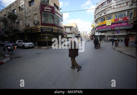 Nablus, West Bank, Palestina, 31 marzo 2018. Un uomo cammina passato negozi chiusi come Palestinesi osservare uno sciopero generale in solidarietà con la striscia di Gaza e la 15 palestinesi che sono stati uccisi ieri durante il grande ritorno a marzo si scontra in Cisgiordania città di Nablus, 31 marzo 2018. Foto: Ayman Nobani/dpa Foto Stock