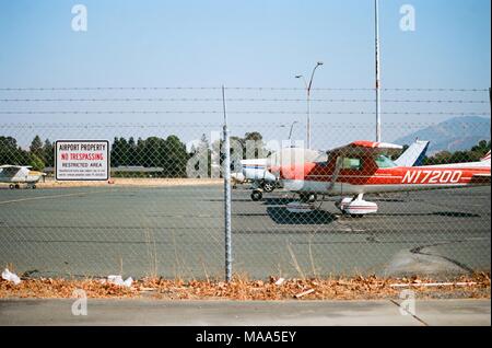 Piccoli aeromobili leggeri sono parcheggiate su asfalto dietro una recinzione al campo di Buchanan Aeroporto una Municipal Airport serve Contra Costa County, Concord, California, 8 settembre 2017. () Foto Stock