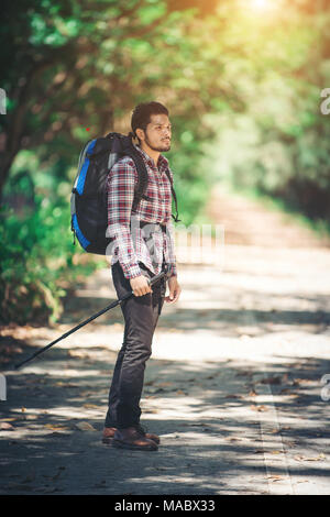 Hipster uomo escursionista azienda poli e guardando lontano. Foto Stock
