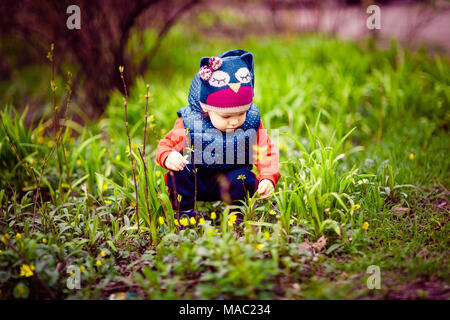 Bambino a caccia di fiori sulla strada Foto Stock