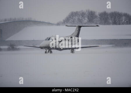 Sovrano business jet Embraer EMB-500 Phenom 100 biz getto G-ITSU in rullaggio a Londra aeroporto di Southend ricoperta di neve bestia da est meteo Foto Stock